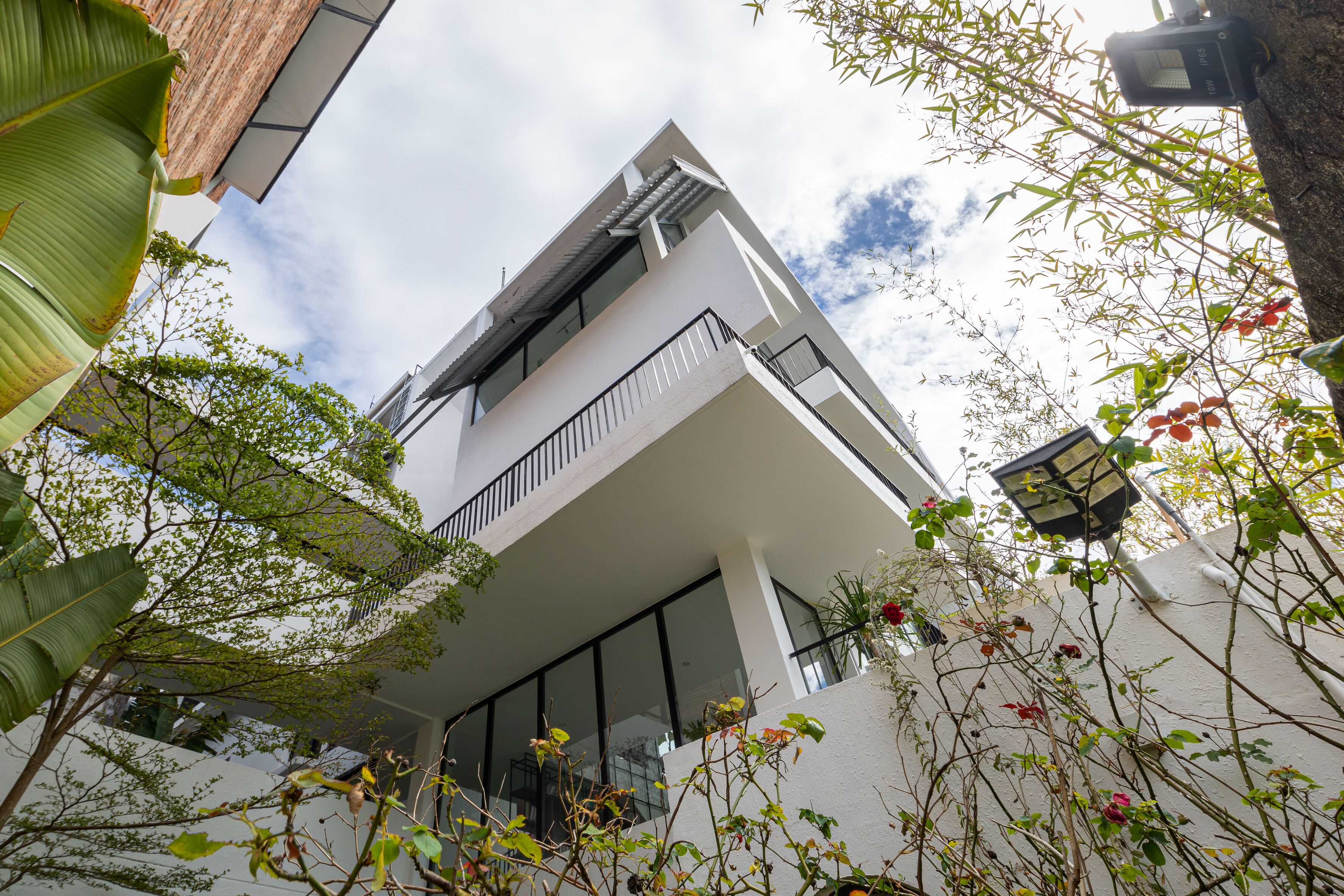 Un bâtiment moderne avec une façade blanche, de grandes fenêtres et un balcon.
