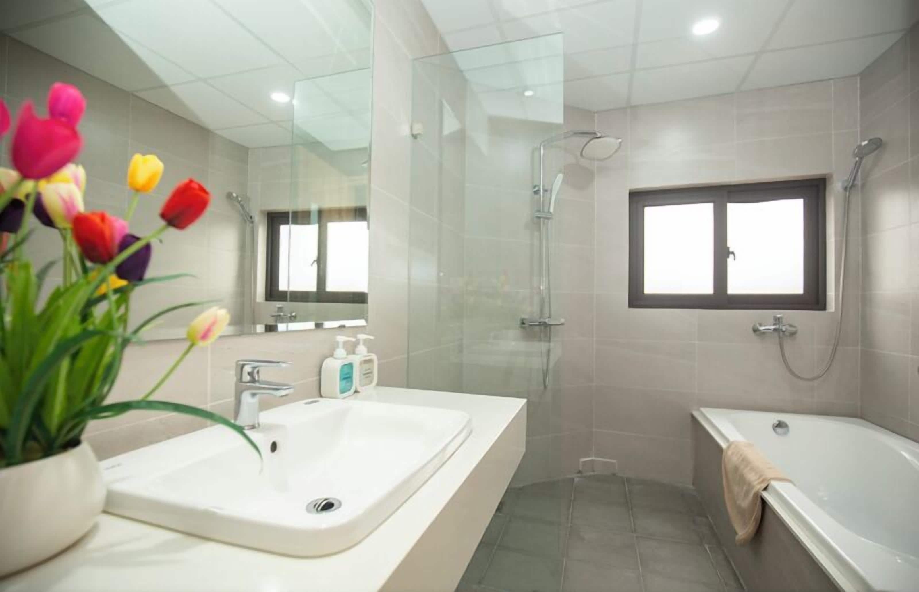 Ein modernes Badezimmer mit einem großen Waschbecken, einer Dusche und einer Badewanne.