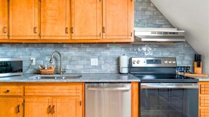 A kitchen with wooden cabinets, a stainless steel dishwasher, an oven, and a microwave. - Charming 1 BR Atlanta Retreat: Minutes to Midtown (Atlanta)