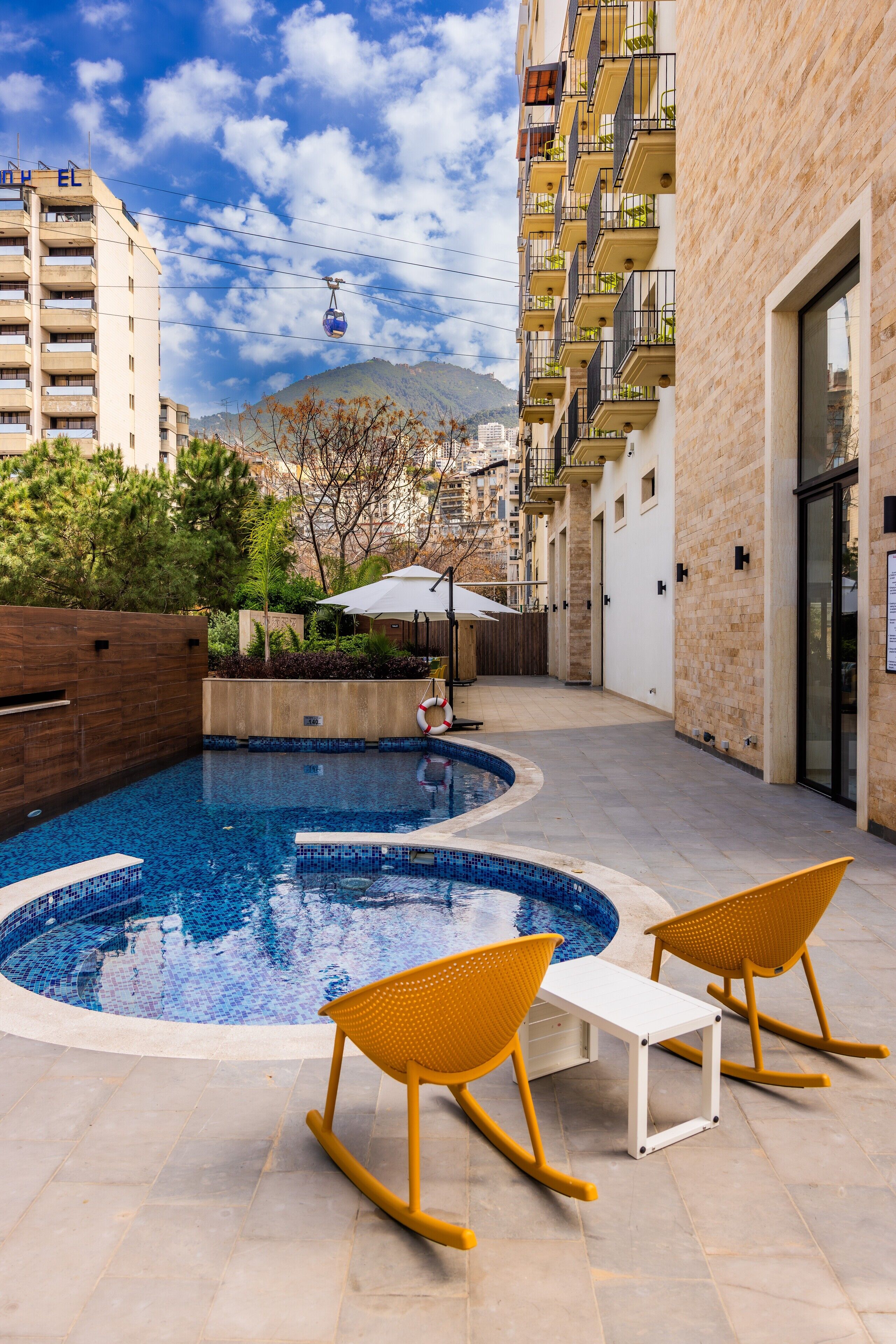 Alberca al aire libre, sombrillas en la alberca y camastros 