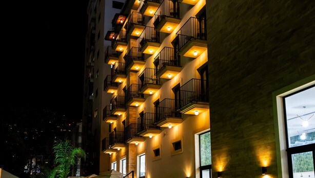 A hotel with a swimming pool, outdoor lighting, and a building facade with balconies. - Le Grove Hotel (Jounieh)