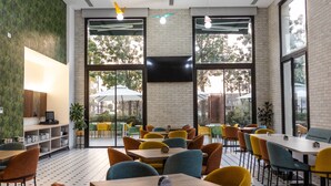 A spacious indoor dining area with multiple tables and chairs, large windows, and a modern ceiling design. - Le Grove Hotel (Jounieh)