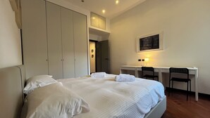 Une chambre d’hôtel avec un grand lit, un bureau et une chaise.