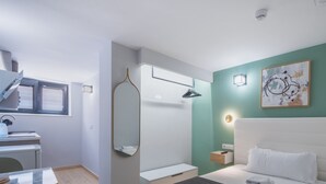 Un dormitorio moderno con una cama, una mesita de noche, un espejo, una ventana y un aplique de pared.