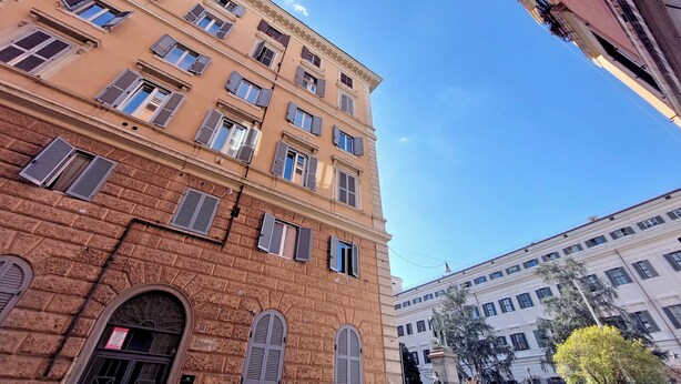 A multi-story building with a classic architectural style, featuring arched windows and a brick facade. - Cozy new flat near the Station! (Roma)