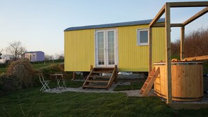 A yellow mobile home with a front porch, a wooden deck, and a hot tub. - Primrose (With Hot-Tub) (Reynalton)