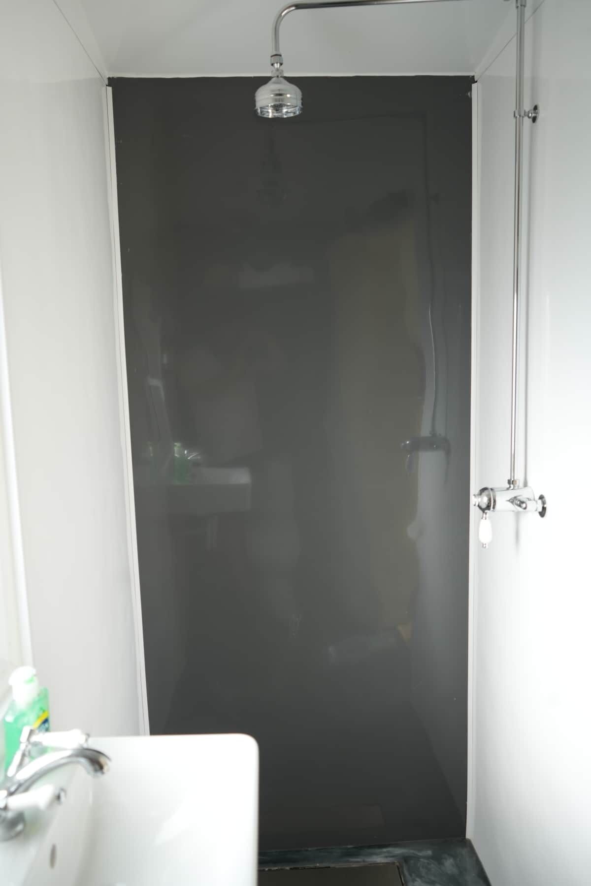 A bathroom with a shower, a sink, and a mirror.