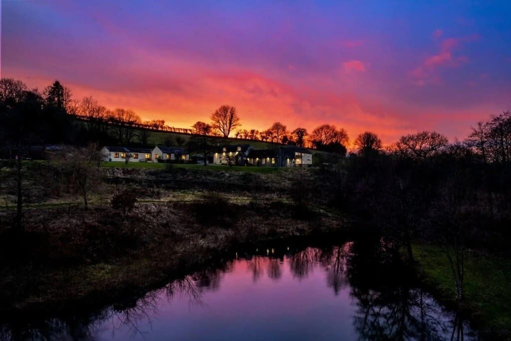 A row of houses along a water body at sunset.