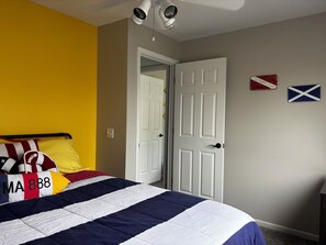 Ein Schlafzimmer mit einem Bett, einer Tür und zwei Wimpeln an der Wand.