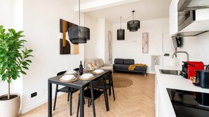 Une cuisine moderne avec un coin repas, un canapé et une plante en pot.