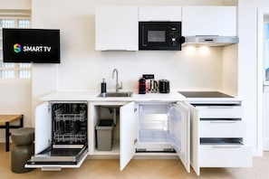 A modern kitchen with built-in appliances, a dishwasher, and a TV displaying 'SMART TV'. - DomusNova Finestra Penthouse historic center Turin (Torino)