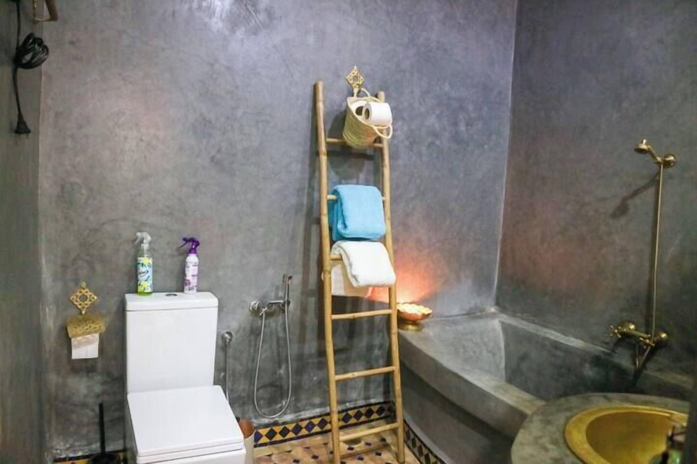 Een badkamer met toilet, wastafel, douche en bad.