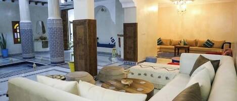 A spacious living area with a sofa set, coffee table, and decorative elements.