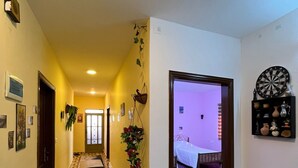 Un pasillo con alfombra estampada, un dardo y una cama en la habitación contigua.