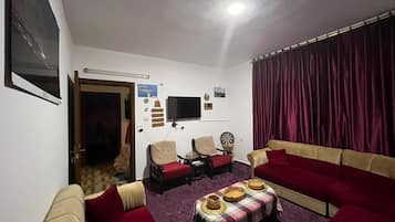 Apartamento, varanda coberta, vista para o pátio | Área de estar | TV, livros