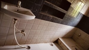 A bathroom with a sink, a shower, and a tiled floor. - Hotel Gayatri Palace (Chandauli)