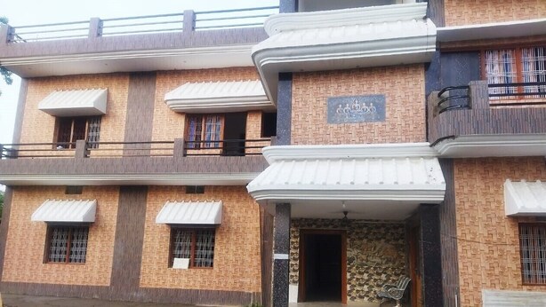 A multi-story building with a brick facade, multiple balconies, and awnings over the windows. - Hotel Gayatri Palace (Chandauli)