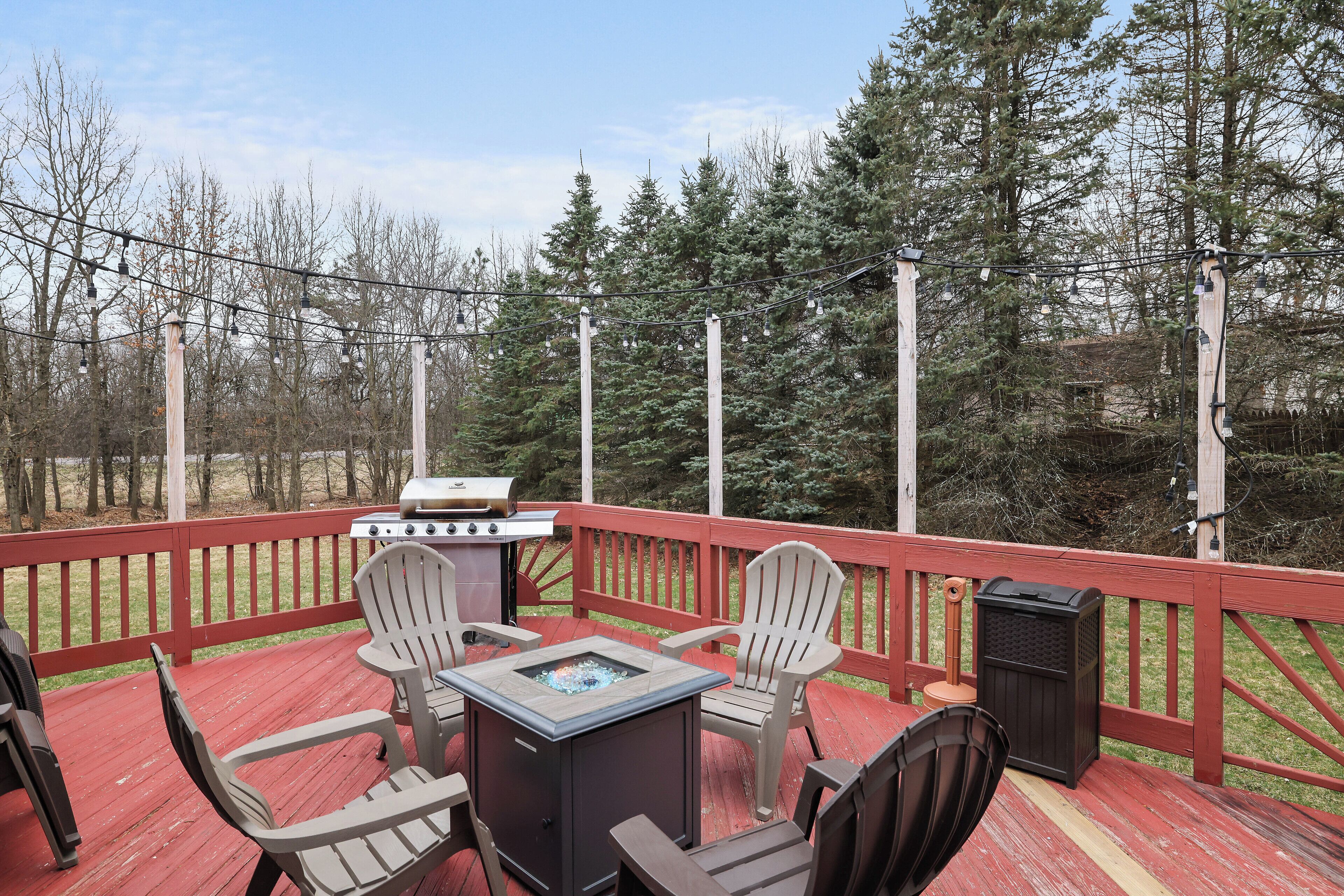A deck with outdoor furniture, a grill, and a fire pit.