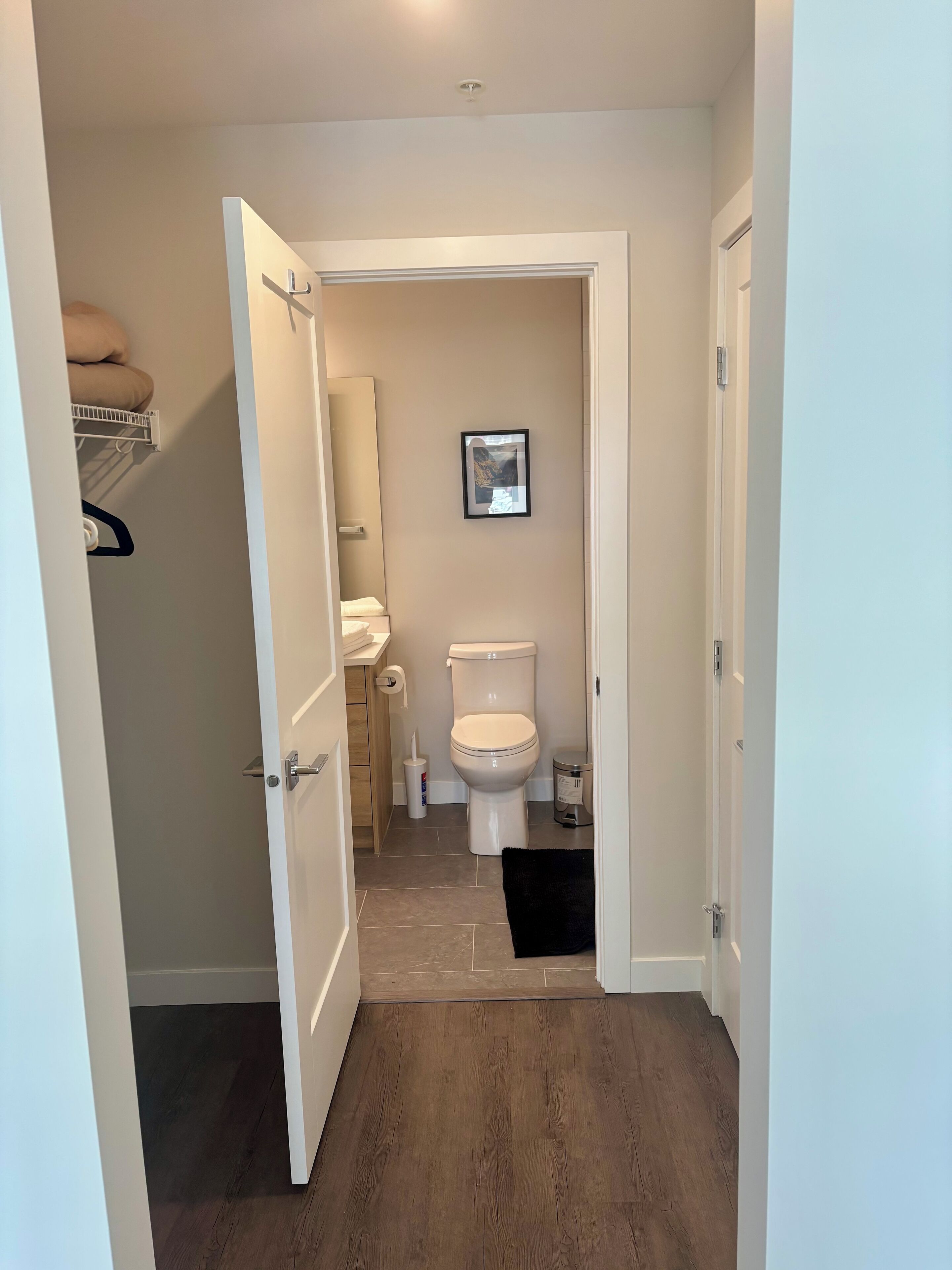 A modern bathroom with a toilet, sink, and storage cabinet.