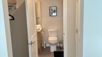 A modern bathroom with a toilet, sink, and storage cabinet.
