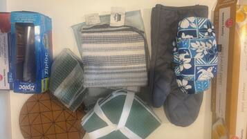 A drawer containing various items including a box of Ziploc bags, a patterned fabric, a pair of socks, and a decorative bowl.