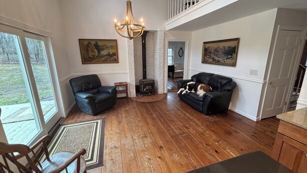 A cozy living room with a fireplace, leather sofas, a wooden rocking chair, and a chandelier. - Large 3-bedroom house in a quiet neighborhood in the village of Canton, NY (Canton)
