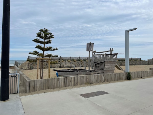 A wooden fence, a metal gate, and a concrete pathway.
