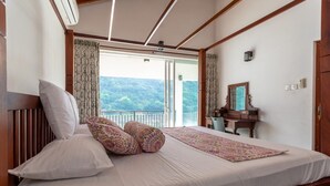 A bedroom with a bed, a wooden headboard, a nightstand, a dresser, a mirror, and a view of the outdoors. - Villa Victoria Edge  (Digana)