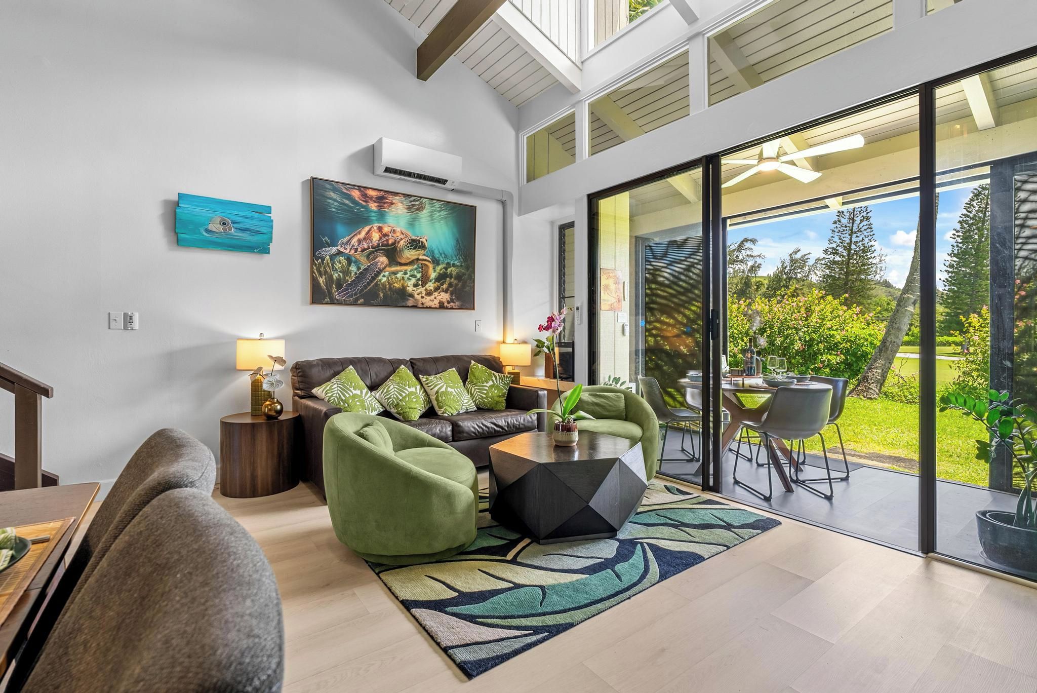 A modern living room with a sofa, coffee table, and a view of the outdoors.