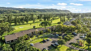 A golf course with a clubhouse, parking area, and surrounding greenery. - Turtle Bay Hale: Fully Renovated 2025, Beach-Pool-Golf Course Frontage-A/C (Kahuku)
