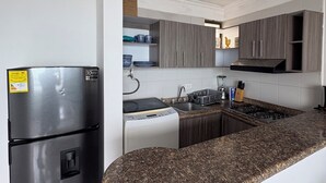 Una cocina moderna con una isla integrada, electrodomésticos de acero inoxidable y armarios de madera.