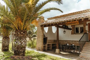 A patio area with outdoor seating, a brick wall, and a sign reading "Bienvenidos".