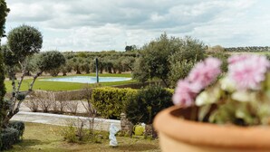 Ein Garten mit Swimmingpool, einer Statue und Blick auf die Landschaft.
