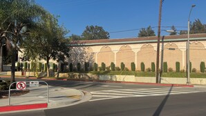 A street view with a building featuring arched windows and a red-tiled roof. - All 8 Motel (Azusa)