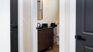 A bathroom with a modern sink, a mirror, and a toilet.