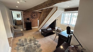 A spacious living area with a fireplace, a staircase, and a view of the outside.