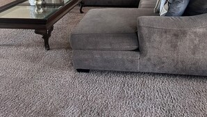A living room with a sectional sofa, a glass coffee table, a ceiling fan, and a painting on the wall. - Beautiful 3-bedroom 2-baths with a pool and RV parking. (Bakersfield)