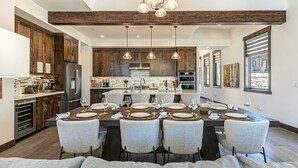 Una cocina moderna con armarios de madera, electrodomésticos de acero inoxidable y una isla central con asientos.