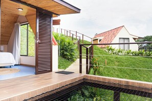 Une chambre moderne avec un plafond en bois, un lit et une vue sur un jardin verdoyant.