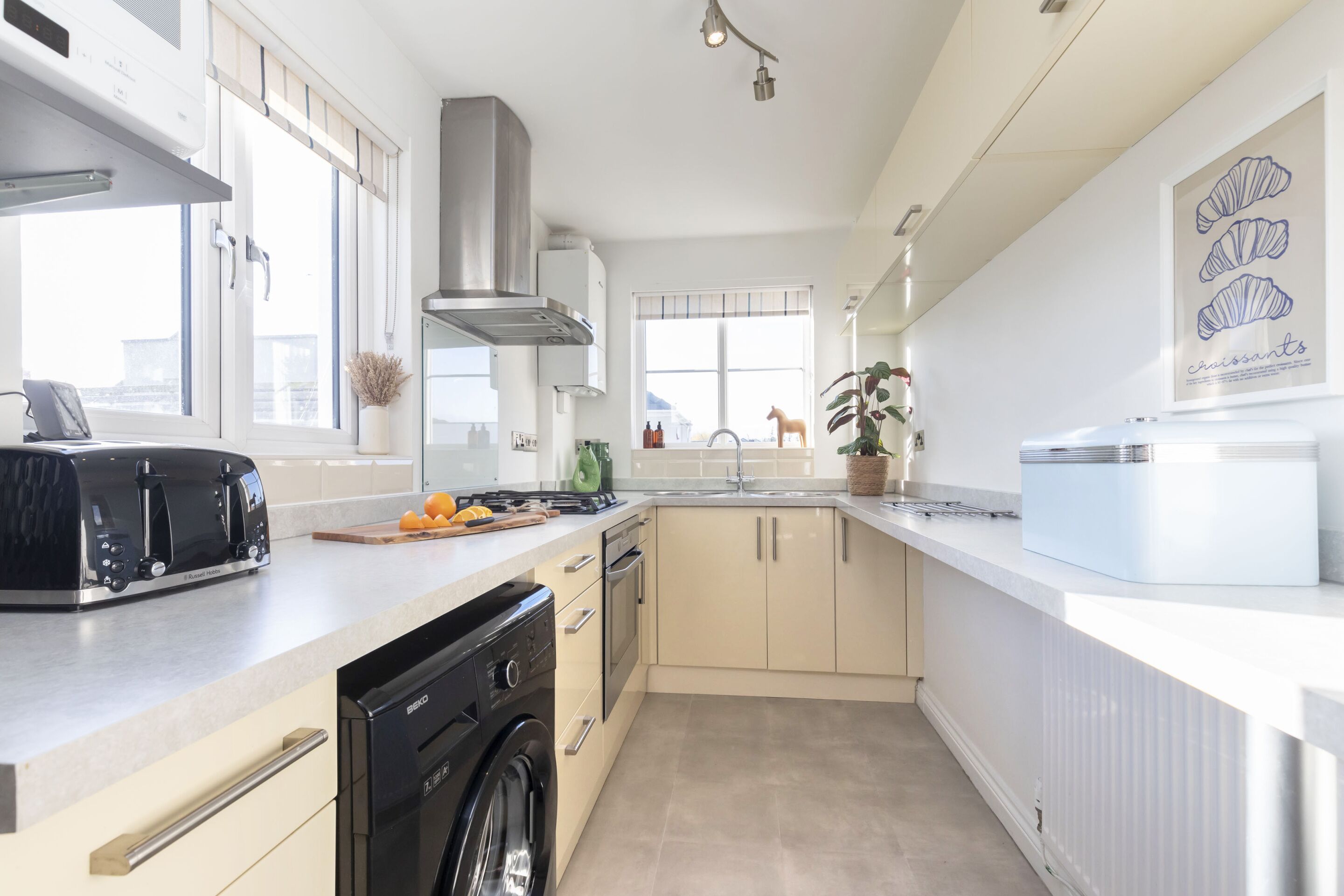 A modern kitchen with a dishwasher, stove, and a toaster.