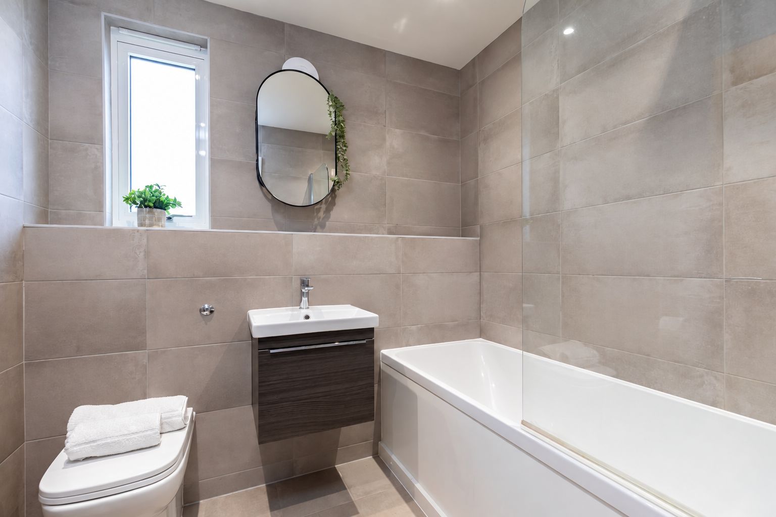Une salle de bain moderne équipée de toilettes, d’un lavabo et d’une baignoire.