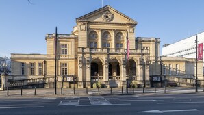 A classical building with a symmetrical facade, large windows, and a central entrance. - Tranquil Home on Leckhampton Hill with EV Charger (Charlton Kings)