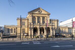 A classical building with a symmetrical facade, large windows, and a central entrance. - Tranquil Home on Leckhampton Hill with EV Charger (Charlton Kings)