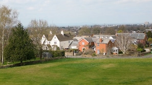 Een woonwijk met huizen, een grasveld en een vergezicht op een stad.