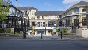 A building with a ground floor featuring a restaurant named "Kitchens by Lorna" and a sign for "The Courtyard." - Tranquil Home on Leckhampton Hill with EV Charger (Charlton Kings)