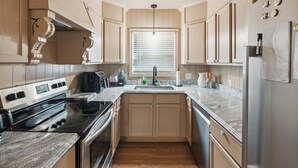 A modern kitchen with a built-in stove, a sink, and wooden cabinets. - Urban Delight  (Detroit)