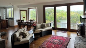 A spacious living room with a sofa, a dining table with chairs, and a kitchen area.