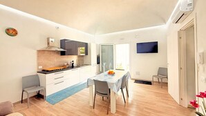 Een knus woongedeelte met een kitchenette, een eethoek en een gezellig zitje.