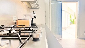 Een moderne keuken met een gasfornuis, een magnetron en een koffiezetapparaat.
