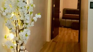 A hallway with a wooden floor, a white flower arrangement, and a piano in the background. - 2 bedroom family apartment in front of the beach on the malecon of san cristobal (Puerto Baquerizo Moreno, San Cristóbal)